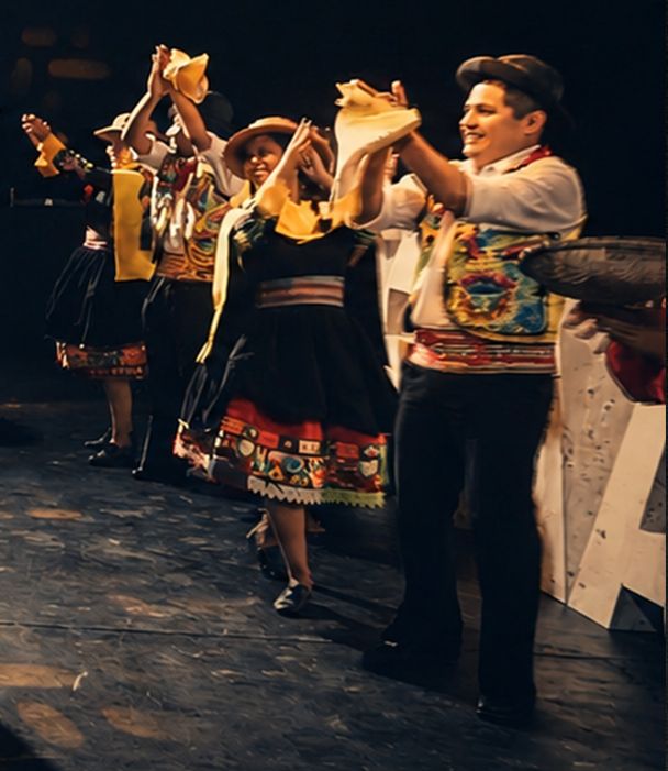 Comparsa de bailarines andinos agitando pañuelos